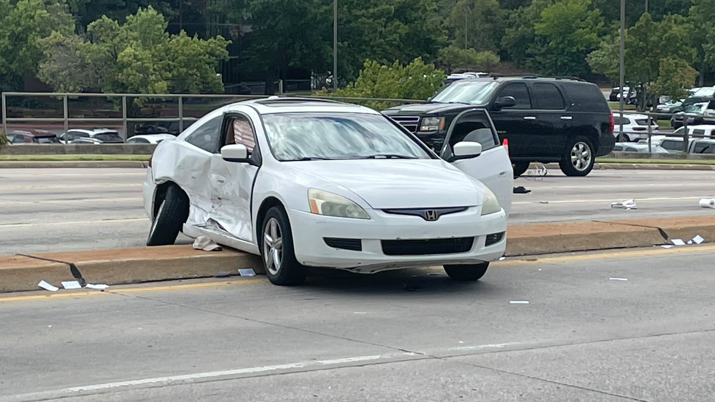 Two cars collided, sending one spinning onto the median where it struck two men soliciting donations.