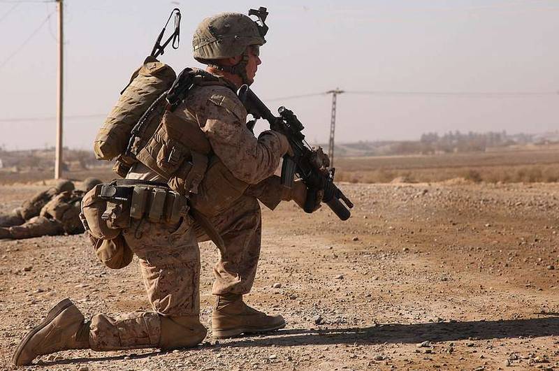 Corporal Brendan O'Bryant, a team leader with 1st Platoon, Kilo Company, 3rd Battalion, 5th Marine Regiment, kneels during a security patrol in Sangin, Afghanistan, Dec. 22, 2010. The Marines frequently patrolled from their company's position to an established patrol base to keep the road clear of improvised explosive devices and monitor changes in the area. (U.S. Marine Corps photo by Sgt. Dean Davis/Released)